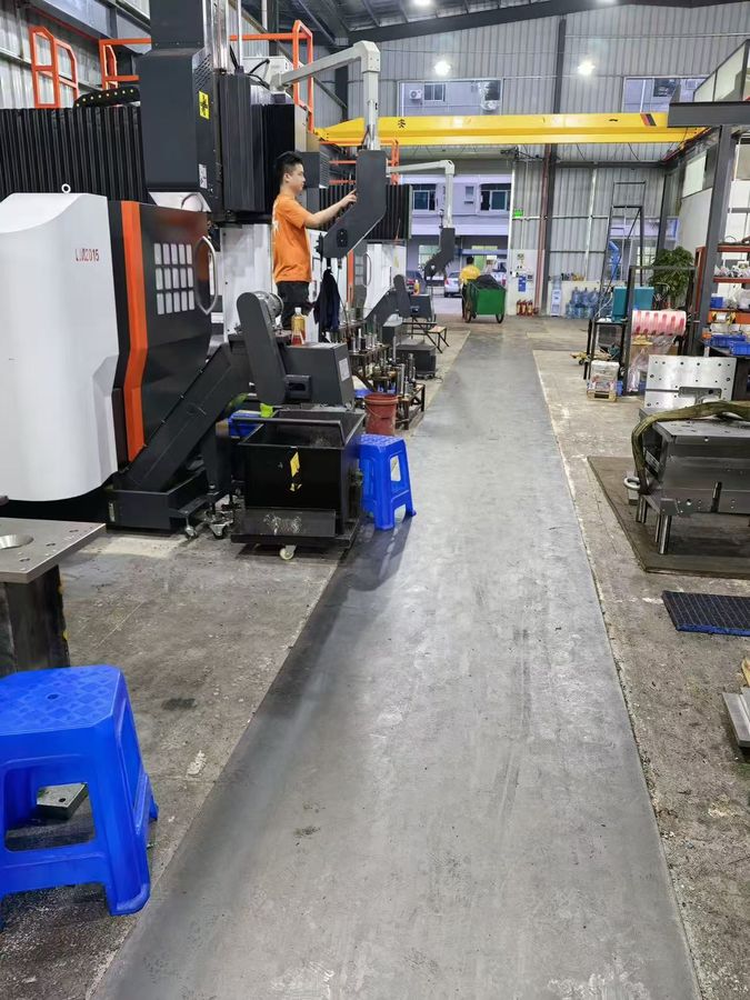 Workshop aisle with double-column CNC machines and overhead crane